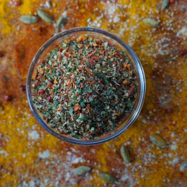 Bunte Gewürzflocken aus roten Tomaten- und Paprikastücken mit grünen Kräutern