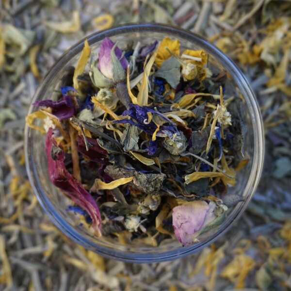 Kräuterteemischung mit grünen, rosa, blauen und gelben Blütenbestandteilen