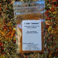 Chili Jolokia gemahlen als feines, orange-rotes Pulver